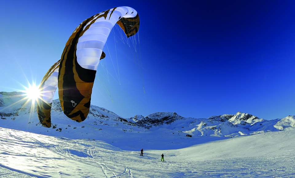 txn-p. Snow Kiten ist ein Wintersport der etwas anderen Art. Auf Skiern oder Snowboards flitzen Actionfans an Lenkdrachen über vereiste Schneefelder. Foto: stipi/Fotolia/jochen-schweizer.de