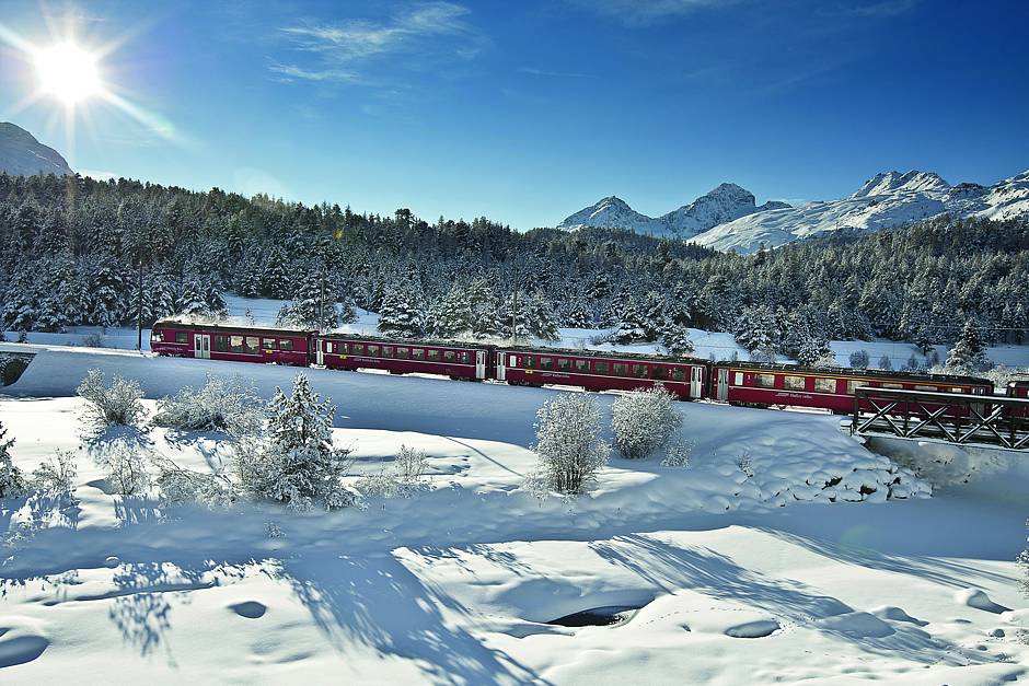 txn. Ein unvergessliches Erlebnis: mit der Rhätischen Bahn in komfortablen Panoramawagen die schneebedeckten Alpen überqueren. Die Tagestour ist für viele Schweiz-Urlauber der Höhepunkt ihres Winterurlaubs. Foto: Rhätische Bahn/txn