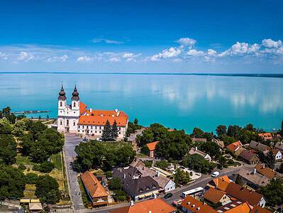 Tihany, Ungarn – Luftaufnahme des berühmten Benediktinerklosters von Tihany (Abtei von Tihany) mit dem wunderschönen, farbenprächtigen Plattensee im Hintergrund